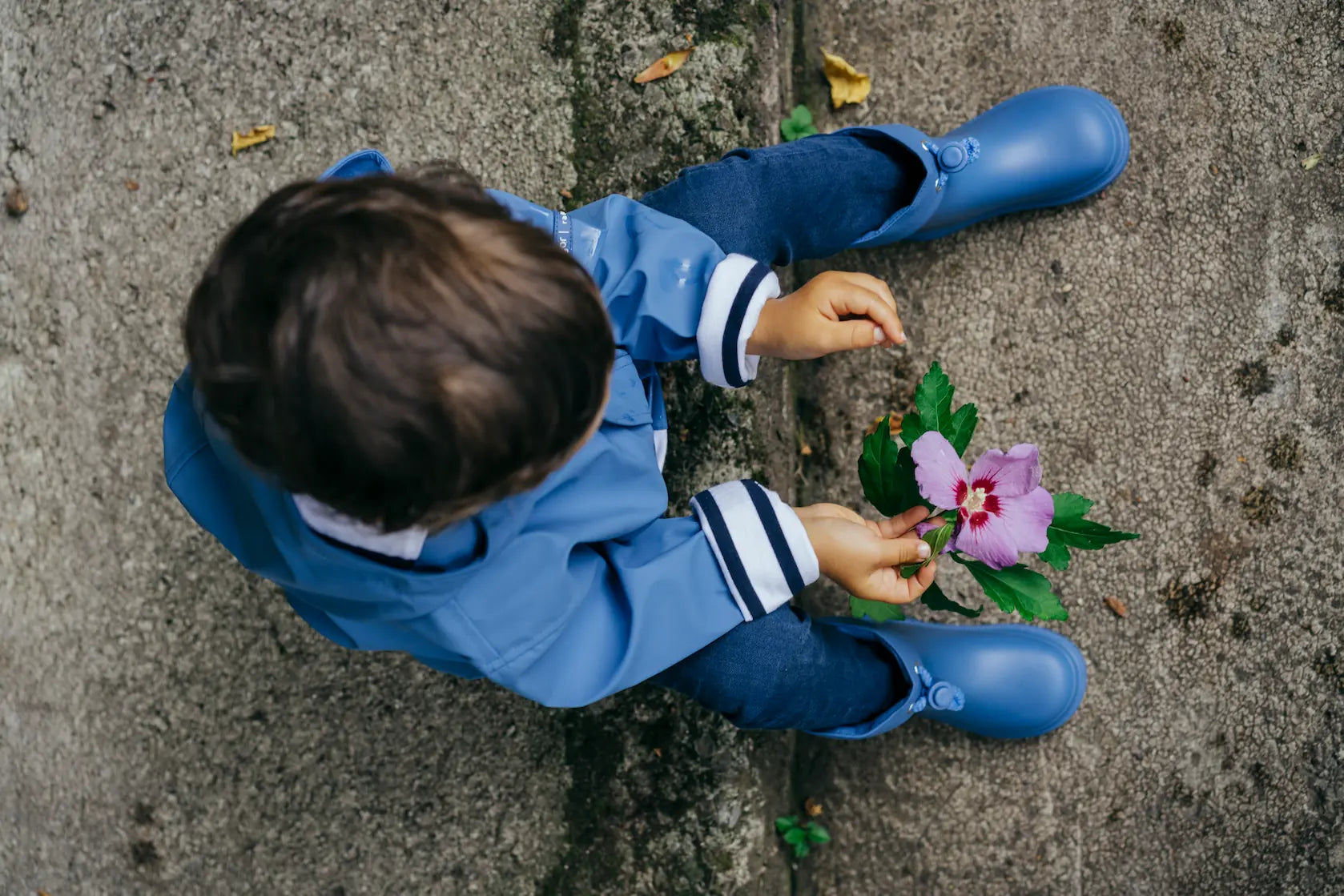 enfant en bottes de pluie bleues