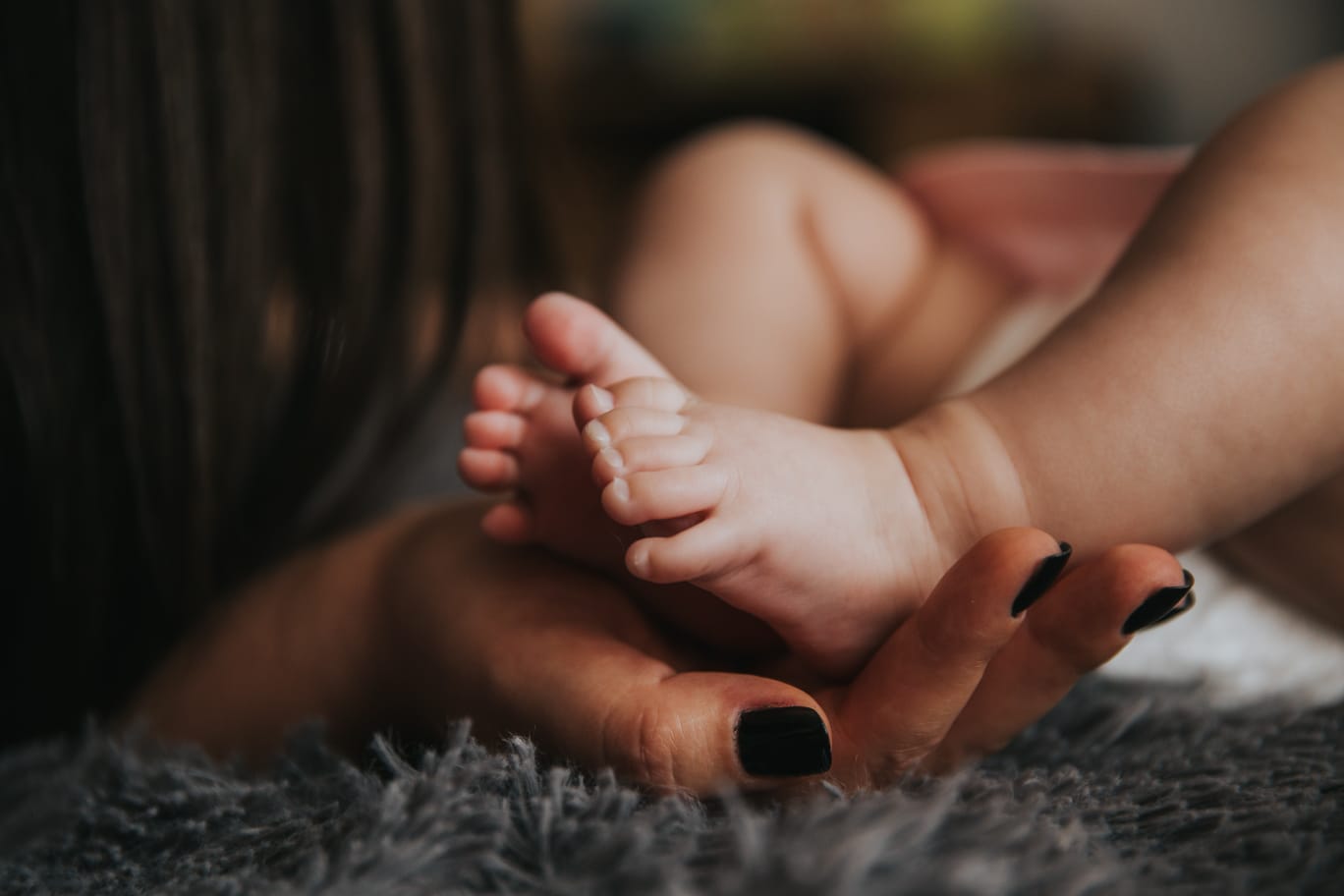 pieds de bébé dans la main de maman
