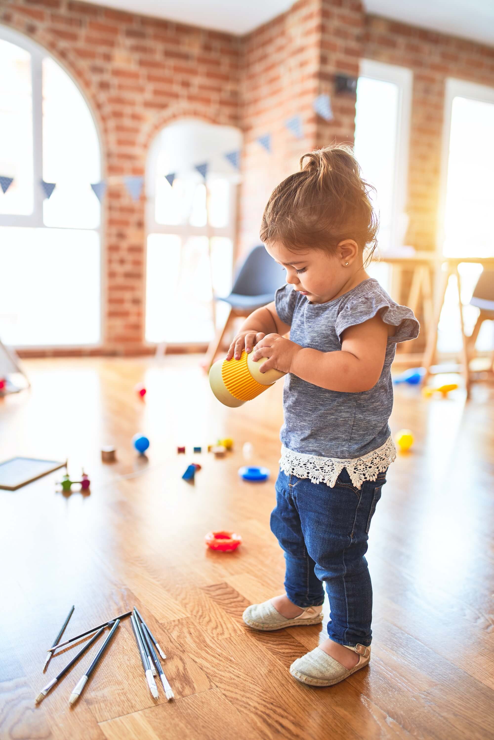 bébé jouant dans une grande salle éclairée pleine de jouets