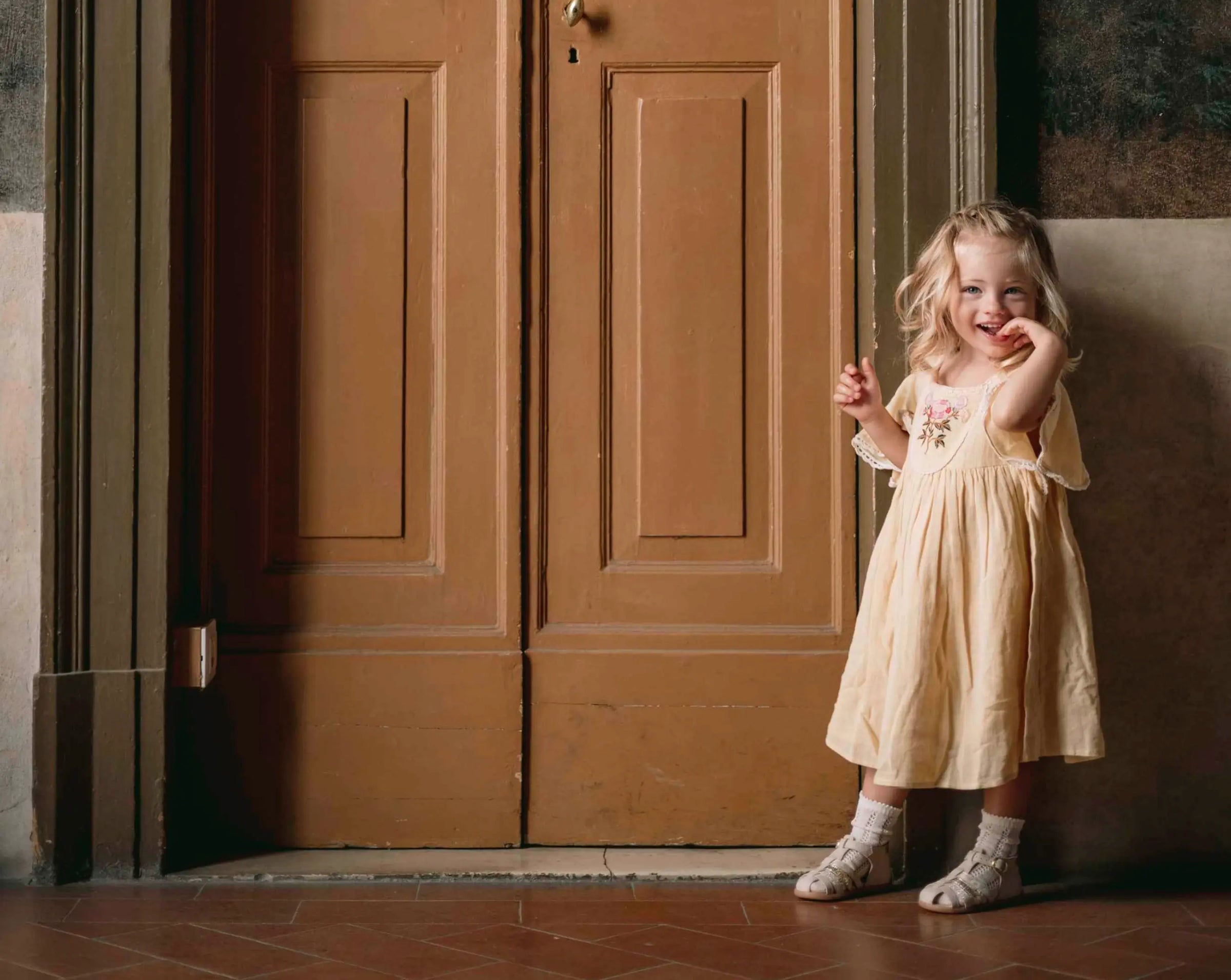petite fille blonde devant porte